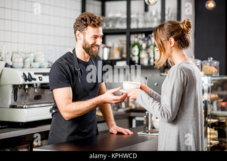 Barista con il cliente presso il cafe Foto Stock