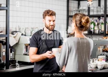 Barista con il cliente presso il cafe Foto Stock