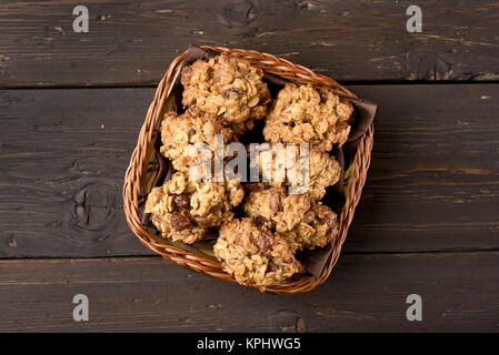 Avena sana i cookie nel cestino del pane su sfondo di legno. Vista superiore, laici piatta Foto Stock