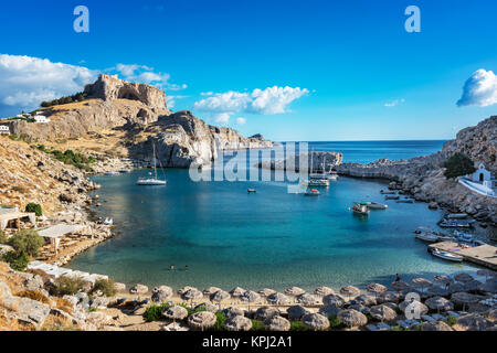 Bellissima spiaggia nella baia di San Paolo, Lindos acropoli di sfondo (Rhodes, Grecia) Foto Stock