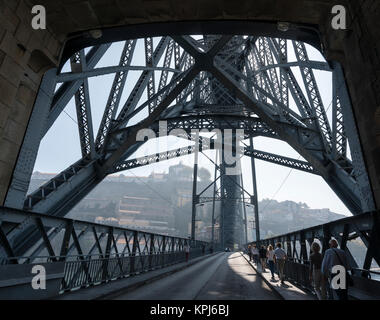 Pedoni che attraversano il Dom Luis I ponte che attraversa il fiume Douro nel quartiere Ribeira di Porto, Portogallo. Foto Stock