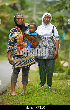 Le donne musulmane, 37 e 45 anni, con il bambino in imbracatura, Losari Village, Magelang, Java, Indonesia Foto Stock