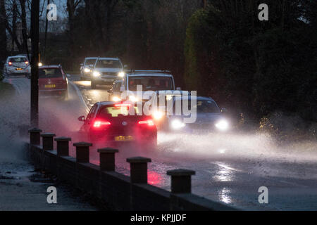 La guida di veicoli attraverso strade allagate al tramonto a causa di neve fusa causando interruzioni sulle strade di Chester, Cheshire Foto Stock