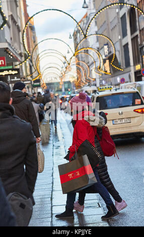 Amburgo, Germania. Xvi Dec, 2017. Due donne portano borse per lo shopping nel centro della città di Amburgo, Germania, 16 dicembre 2017. Le luci di Natale può essere visto in background. Credito: Georg Wendt/dpa/Alamy Live News Foto Stock