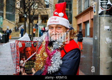 Glasgow, Scotland, Regno Unito. 16 dicembre, 2017. Come migliaia di acquirenti accorsi per Glasgow City Centre e in particolare Buchanan Street noto anche come Glasgow miglio stile molti sono entrati nello spirito stagionale e ci siamo goduti il divertimento da musicisti di strada e artisti di strada. L'immagine è di Paul Kelly che è stata senzatetto e di vendere il grande problema per 5 mesi di credito: Findlay/Alamy Live News Foto Stock