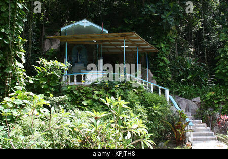 Santuario cristiano con la Vergine Maria sul lato di una strada, La Digue Island, Seychelles. Foto Stock