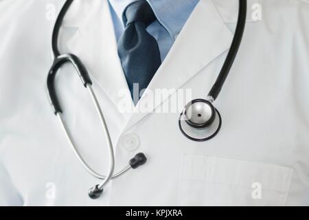 Maschio di dottore in camice bianco con uno stetoscopio, bracci ripiegati. Foto Stock