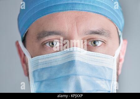 Medico maschio indossando mascherina chirurgica, vicino. Foto Stock