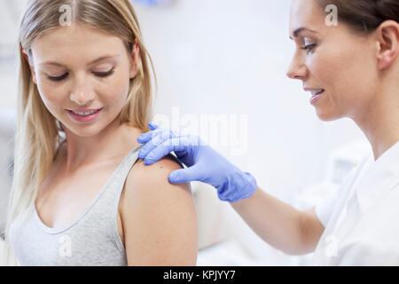 Medico donna esaminando i giovani alle spalle della donna. Foto Stock