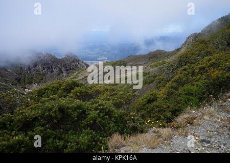 La vista dalla cima del vulcano Baru, Panama a valle con il bianco di nebbia in distanza Foto Stock