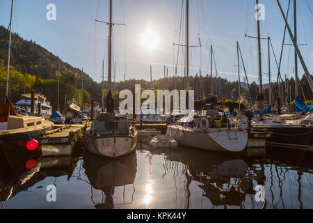 Un tranquillo pomeriggio di sole come il sole tramonta dietro il porto di aderenza Cove, Bowen isola sulla costa occidentale vicino a Vancouver Foto Stock