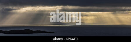 Raggi crepuscolari brilla attraverso le nuvole di tempesta sulle acque dell'oceano; Isola di Skye, altopiani, Scozia Foto Stock