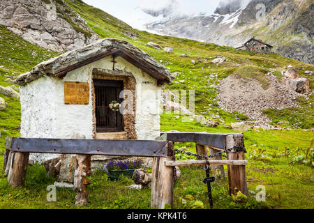 Un piccolo santuario storico a Val Veni con Rifugio Elisabetta in background, Alpi; Valle d'Aosta, Italia Foto Stock