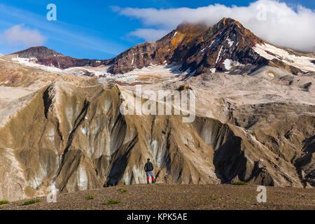 Un uomo è sopraffatte dalla frastagliata, ash-coltello coperta Creek ghiacciai e Trident Vulcano nella Valle dei Diecimila Fumi in Katmai National Park Foto Stock