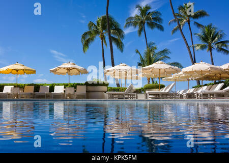 Piscina Halekalani a Waikiki con palme e ombrelloni riflessa nell'acqua; Waikiki Oahu, Hawaii, Stati Uniti d'America Foto Stock