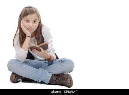 Preteen ragazza legge un libro, seduta attraversato-gambe Foto Stock