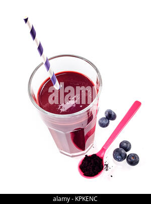 Un bicchiere di miscele di mirtillo e esotici Acai berry drink con paglia accanto a bacche e un cucchiaio di rosa su sfondo bianco Foto Stock