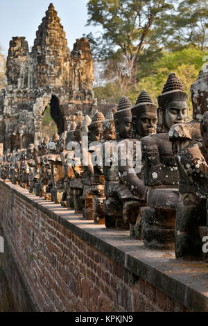 Fila di divinità e la porta sud, Angkor Thom, il Parco Archeologico di Angkor, Siem Reap, Cambogia Foto Stock