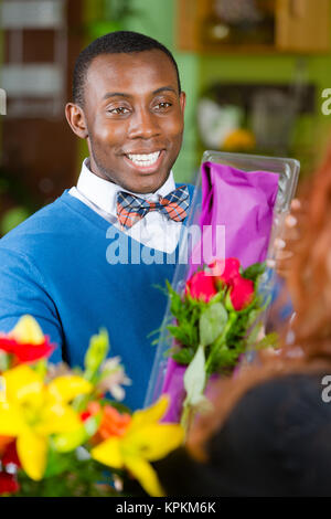 Uomo bello nel negozio di fiori acquista le rose Foto Stock