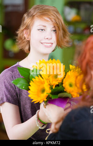 Ragazza nel negozio di fiori gli acquisti di girasoli Foto Stock