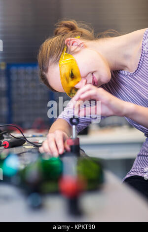 Donna scienziato di effettuare esperimenti di ricerca in un ottica quantistica lab (toni di colore immagine) Foto Stock