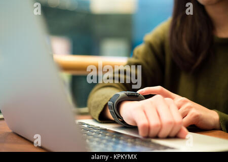 Donna toccare sullo schermo di smart watch Foto Stock