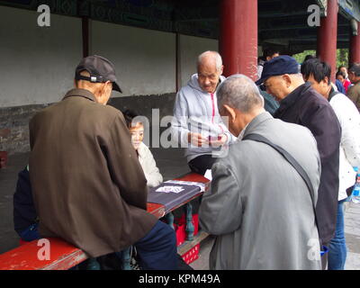 Un gruppo di anziani cinese gioca gioco di carte presso il Tempio del Paradiso. Il viaggio nella città di Pechino, Cina. 20 ottobre, 2017. Foto Stock