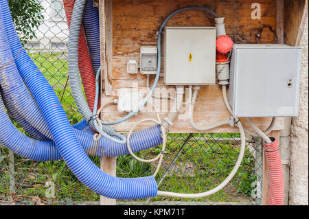 Temporanea pannello elettrico e un contatore di energia elettrica per il lavoro svolto sul sito in costruzione. Foto Stock