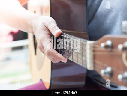 Donna con le mani in mano suonare la chitarra acustica Foto Stock