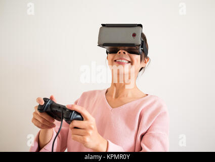 La donna gioca con la realtà virtuale e joystick Foto Stock