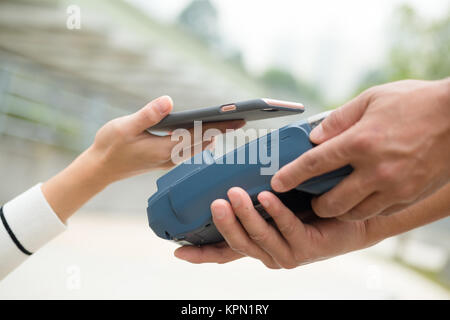 Donna pagare sulla macchina pos con il cellulare Foto Stock