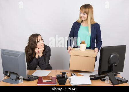 La ragazza in ufficio felicemente sacchetti di contenimento e guardando a un collega Foto Stock