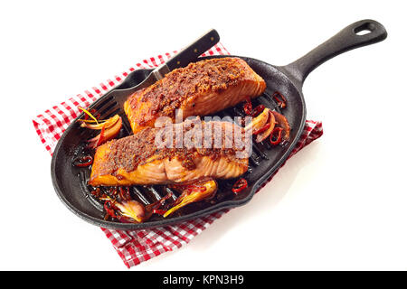 Nutriente salmone al forno di pezzi con marinata di stagionatura in self service pan con la forcella più tovagliolo a scacchi sulla superficie bianca Foto Stock