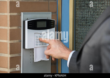 Close-up di commercianti inserendo il codice nel sistema di sicurezza Foto Stock