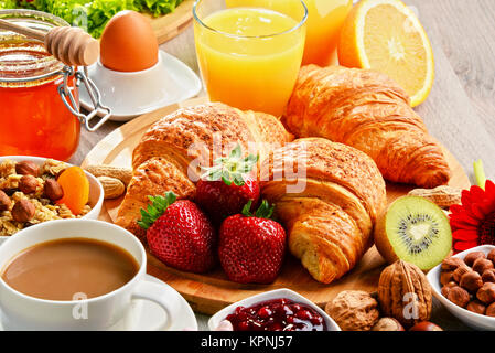 La prima colazione composta da cornetti, caffè, frutta, succo d'arancia Foto Stock