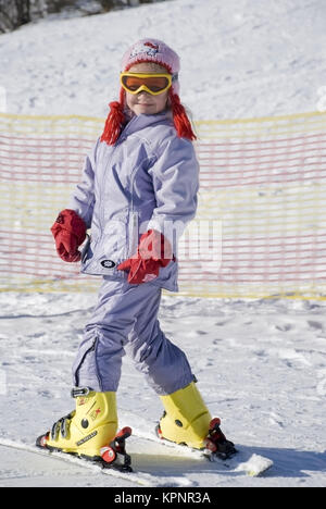 Modello di rilascio , Maedchen, 7 Jahre, im Skioutfit auf der Skiposte - ragazza sci Foto Stock