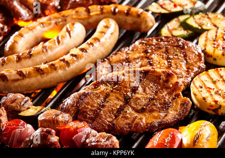 Hot Dog salsicce, carne di manzo, polpette di pollo e verdure su hot flaming grill Foto Stock