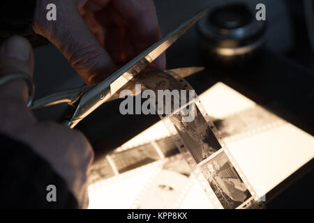 Le mani di un fotografo lavora con pellicola negativ Foto Stock