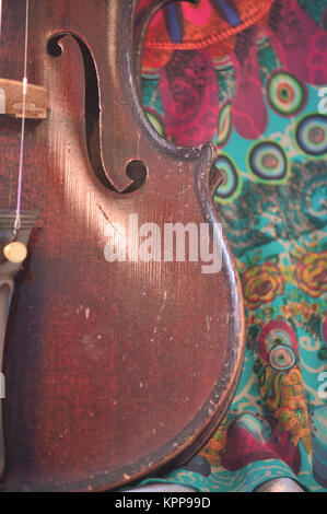 Violino antico closeup contro stravagante Stampa tessuto Foto Stock