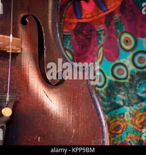 Violino antico closeup contro stampa colorata Foto Stock