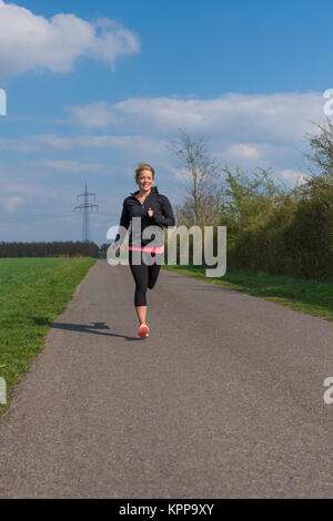 jogger corre su una strada in primavera Foto Stock