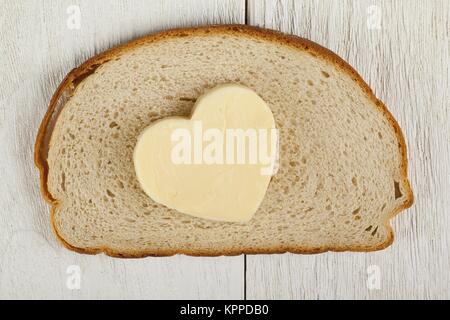 A forma di cuore di burro sul pane Foto Stock