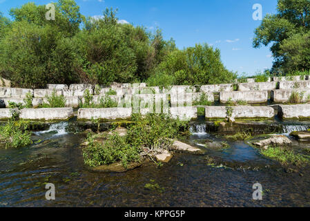 Un calcestruzzo blocchi giacenti su un piccolo fiume - dam Foto Stock