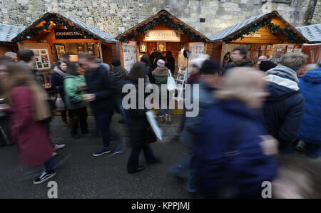 Christmas Shopper fanno il loro modo di circa il mercato di Natale nella motivazione della Cattedrale di Winchester in Hampshire, l'ultima settimana prima di Natale. Foto Stock