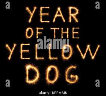 Anno di Yellow Dog lettering disegnato con brillantini bengali isolati su sfondo nero Foto Stock