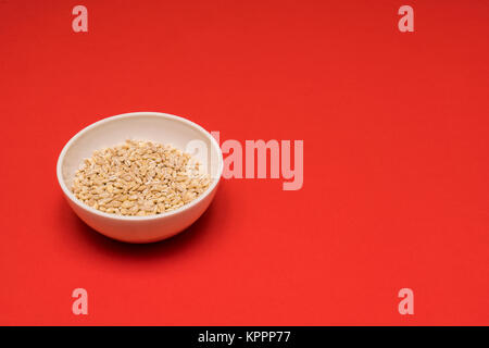 Orzo perlato una ciotola su uno sfondo colorato Foto Stock