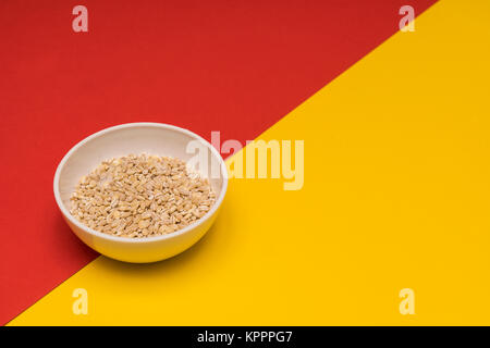 Orzo perlato una ciotola su uno sfondo colorato Foto Stock