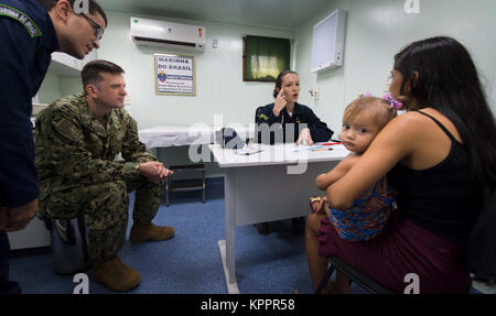 Fiume del Amazon, Brasile (nov. 22, 2017) Lt. La Cmdr. Robert P. Lennon, uno specialista in medicina generale (secondo da sinistra), funziona con 1Lt. Priscila Tomy Ribeiro, un brasiliano medical officer (terza da sinistra), per effettuare la diagnosi di una giovane madre a bordo di NAsH Soares de Meirelles vicino a un remoto villaggio lungo il Rio delle Amazzoni in Brasile, 22 novembre. Lennon è un membro di una squadra di cinque Stati Uniti Navy medici che sono impegnati in un mese di missione umanitaria fino il fiume del Amazon. Il team sta lavorando con la Marina brasiliana per offrire assistenza sanitaria di alcuni dei più persone isolate nel mondo. (U.S. Navy Foto Stock