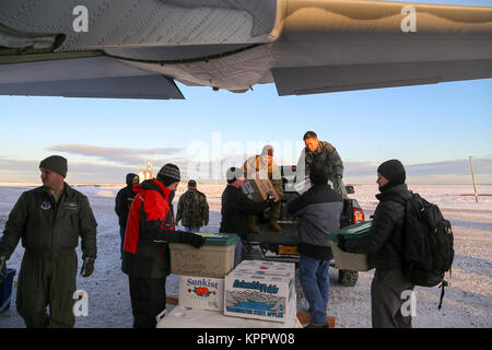 Alaska Air e l esercito nazionale guardie e volontari con il funzionamento di Babbo Natale di scaricare un 211th Rescue Squadron HC-130J contro il re II aeromobili in San Michele, Alaska, su dicembre 5, 2017. Il funzionamento di Santa Claus è un Alaska Guardia Nazionale comunitario annuale programma di outreach che fornisce i regali di Natale, libri, forniture scolastiche, frutta fresca e sundaes per i giovani nelle comunità rurali. (U.S. Esercito nazionale Guard Foto Stock