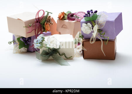 Confezioni regalo con nastro e fiori artificiali su sfondo bianco con spazio copia, immagini di alta qualità Foto Stock